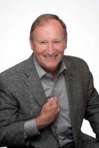 David McArthur smiling, with his hand over his heart